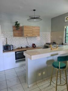 a kitchen with a counter and some chairs in it at LE COROSSOL APPART in Mamoudzou