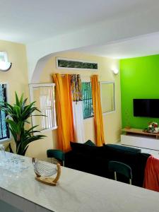 a living room with green walls and a couch at LE COROSSOL APPART in Mamoudzou