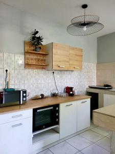 a kitchen with white cabinets and a microwave at LE COROSSOL APPART in Mamoudzou