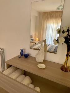 Zimmer mit einem Tisch mit einem Spiegel und einem Schlafzimmer. in der Unterkunft VISTAMARE apartments Reggio Calabria in Reggio di Calabria