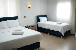 a hotel room with two beds and a window at GRAND CLOVER otel in Seyhan