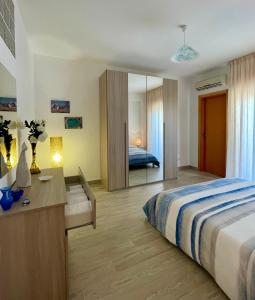 Schlafzimmer mit einem Bett, einem Schreibtisch und einem Spiegel in der Unterkunft VISTAMARE apartments Reggio Calabria in Reggio di Calabria