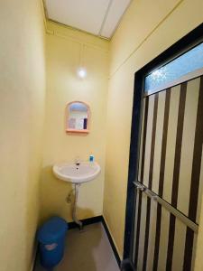 Elle comprend une petite salle de bains pourvue d'un lavabo et d'une fenêtre. dans l'établissement Krupasagar Homestay, à Malvan