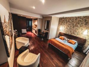リモージュにあるVILLA FLEURY - APPART'HÔTEL DE STANDINGのベッドと椅子付きのホテルルーム