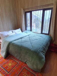 a bedroom with a large bed with a window at Aum 108 Retreat - Rishikesh Mountains in Rishīkesh