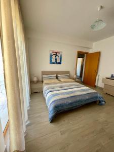 ein Schlafzimmer mit einem großen Bett und einer gestreiften Decke in der Unterkunft VISTAMARE apartments Reggio Calabria in Reggio di Calabria