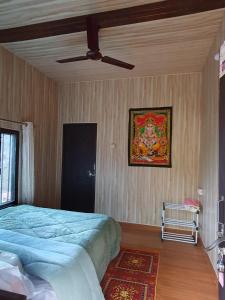 a bedroom with a bed and a painting on the wall at Aum 108 Retreat - Rishikesh Mountains in Rishīkesh