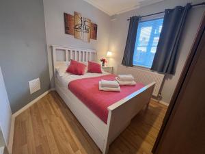 a bedroom with a bed with two towels on it at Croydon apartment with parking in London