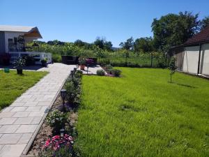 a backyard with green grass and a brick walkway at Ferienwohnung Füssel NICHT FÜR MONTEURE in Bad Staffelstein +2 photos