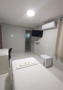 a room with a white bed in a room at Pousada Chapada do Araripe in Araripina