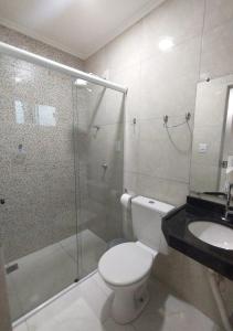 a bathroom with a shower and a toilet and a sink at Pousada Chapada do Araripe in Araripina