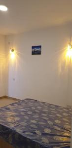 Cette chambre comprend un lit et deux lumières sur le mur. dans l'établissement ANILLAH APPARTMENTS, à Centre de Flacq