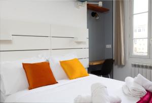 - une chambre avec un lit doté d'oreillers orange et blancs dans l'établissement Stunning 1-bedroom apartment in a vibrant neighborhood of Montmartre, à Paris