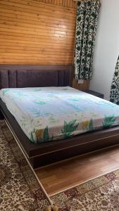 Ce lit se trouve dans un dortoir doté d'un mur en bois. dans l'établissement Zebervan Retreat, à Srinagar