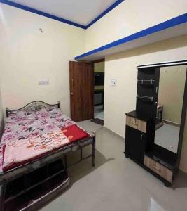 a bedroom with a bed and a dresser and a mirror at The bluebird residence in Mysore