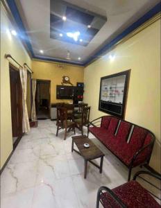 a living room with a red couch and a table at The bluebird residence in Mysore