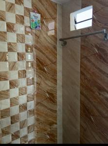 a bathroom with a shower with a wooden wall at The bluebird residence in Mysore