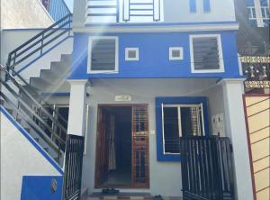 a blue and white house with stairs and a door at The bluebird residence in Mysore