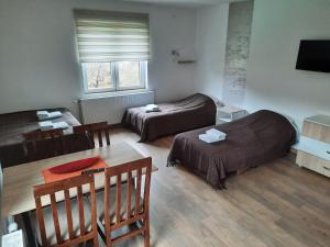 um quarto de hotel com duas camas e uma mesa e uma mesa sidx sidx em BAJKA em Crni Vrh