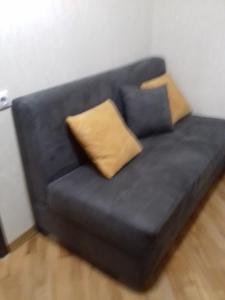 a black couch with two pillows on it at GUEST HAUSE & HOSTEL 15a in Kʼutʼaisi