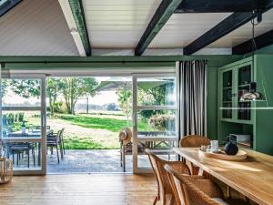a dining room with green walls and a table and chairs at Ferienhaus Hyggeby - Architektenhaus mit Schlei Blick in Ulsnis