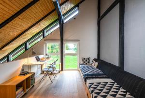 a room with a bed and a desk and windows at Ferienhaus Hyggeby - Architektenhaus mit Schlei Blick in Ulsnis