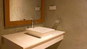 a bathroom with a white sink and a mirror at Diyathra Escape in Galle