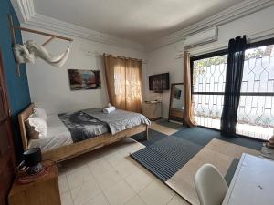 a bedroom with a bed and a large window at Villa Jade in Dakar