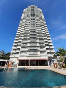 a tall building with a swimming pool in front of it at BEACH FRONT modern room + Free hi speed Wi-Fi in Ban Chak Phai