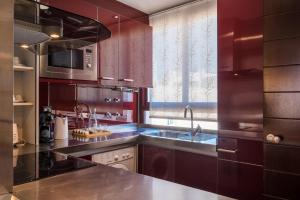 uma cozinha com armários roxos, um lavatório e uma janela em San Bernardo Home Free Parking em Sevilha