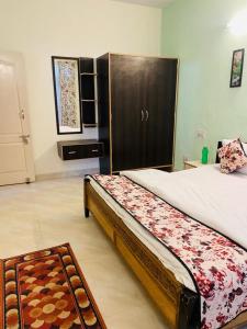 a bedroom with a large bed and a wooden cabinet at Wonder Homes in Shimla