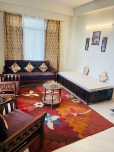 a living room with two beds and a rug at Wonder Homes in Shimla