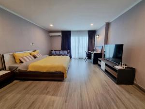a bedroom with a large bed and a flat screen tv at BEACH FRONT modern room + Free hi speed Wi-Fi in Ban Chak Phai