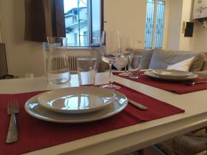 - une table avec une assiette et des verres à vin dans l'établissement Casa vacanze "LaVitaÈAdesso!", à Bergame