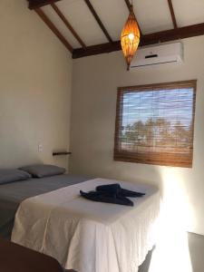a bedroom with two beds and a window at Pousada Porto Taipus in Marau