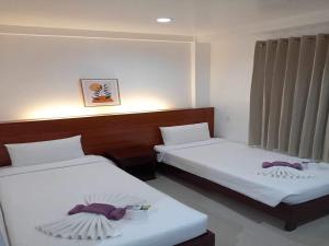 2 bedden in een hotelkamer met zitplaatsen bij Zosimo's Inn in Siquijor
