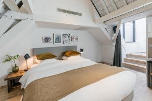 a white bedroom with a large bed and a window at Eye Hotel in Utrecht