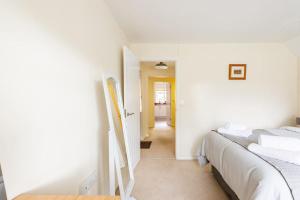 1 dormitorio con 2 camas y pasillo en Lovely Town Centre 1 Bed Nr Country & River Walks, en Gloucestershire