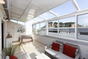 a living room with windows and a couch and a table at Atico Mira-Rosa by costablancarent in Denia