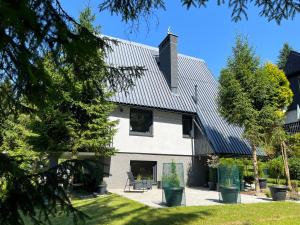 a white house with a metal roof at Dom na Gazownikow12 in Brenna