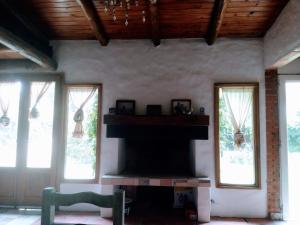 a living room with a fireplace in a house at La Casita in Neuquén