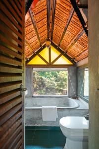 a bathroom with a toilet and a bath tub at The Secret Cove by Stay ALYF, Baga in Baga