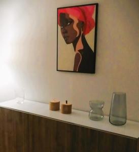 a painting of a woman sitting on a shelf with candles at Arina Home -Aeroporto Fontanarossa- in Catania