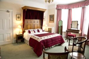 a bedroom with a bed and a table and chairs at Banbury Cross B&B in Banbury