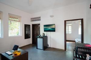 a living room with white walls and a table at The Secret Cove by Stay ALYF, Baga in Baga