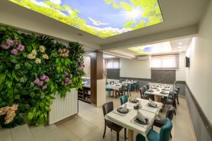 a restaurant with tables and chairs and a ceiling with flowers at Motel Milošević in Bijeljina