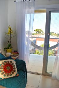 um quarto com um sofá e uma porta de vidro deslizante em Apartamento da Júlio em São Francisco de Paula
