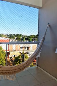 uma rede de descanso num quarto com uma grande janela em Apartamento da Júlio em São Francisco de Paula