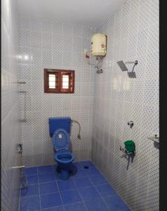 ein Badezimmer mit einem blauen WC und einer Dusche in der Unterkunft Quality Inn Varkala in Varkala