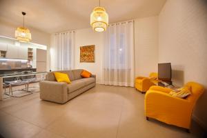 uma sala de estar com um sofá e cadeiras amarelas em Le robbiane 44 - 46 em Florença